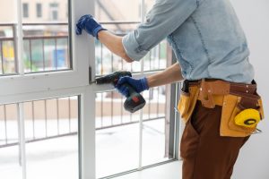 worker drilling and installing windows